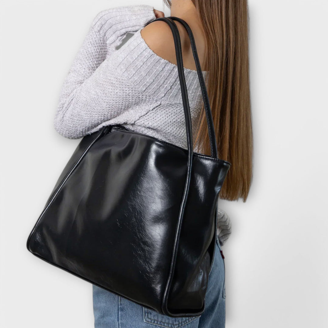 Interno spazioso della borsa Isabelle che mostra vari oggetti personali come un notebook e libri.