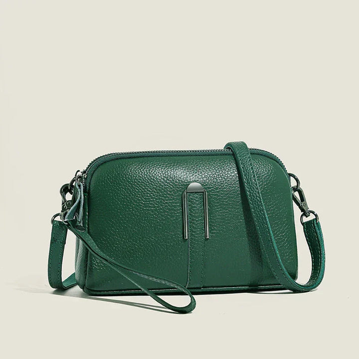 Borsa a tracolla Juliette di colore blu, indossata da una modella in un contesto urbano, evidenziando la versatilità.