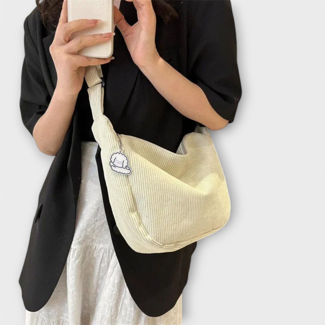 Modella che indossa la borsa a spalla resistente rosa, abbinata a un outfit casual primaverile.