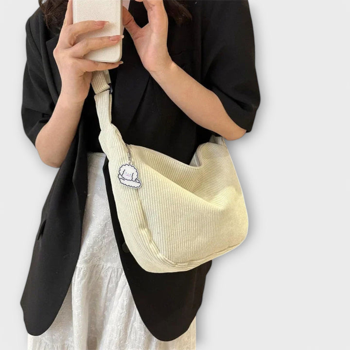 Modella che indossa la borsa a spalla resistente rosa, abbinata a un outfit casual primaverile.