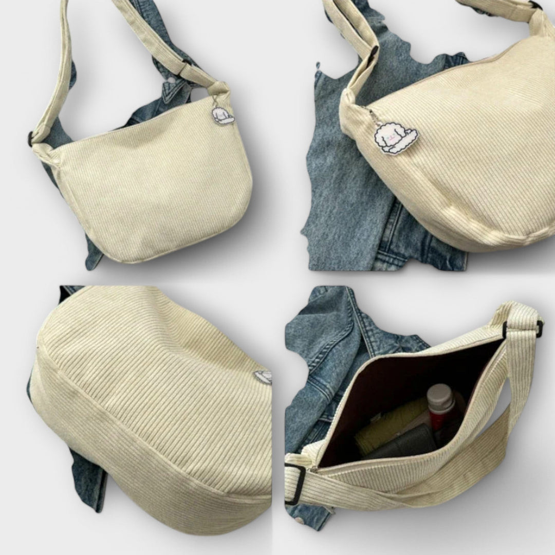 Borsa a spalla resistente marrone chiaro, appoggiata su una superficie in legno, con manico in evidenza.