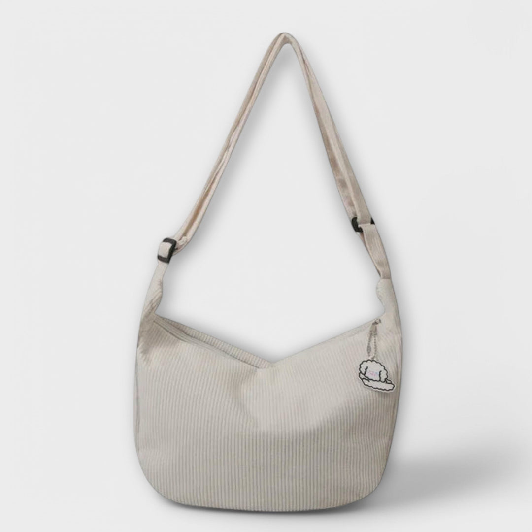 Modella in movimento con la borsa a spalla resistente marrone scuro, catturata in un ambiente urbano.