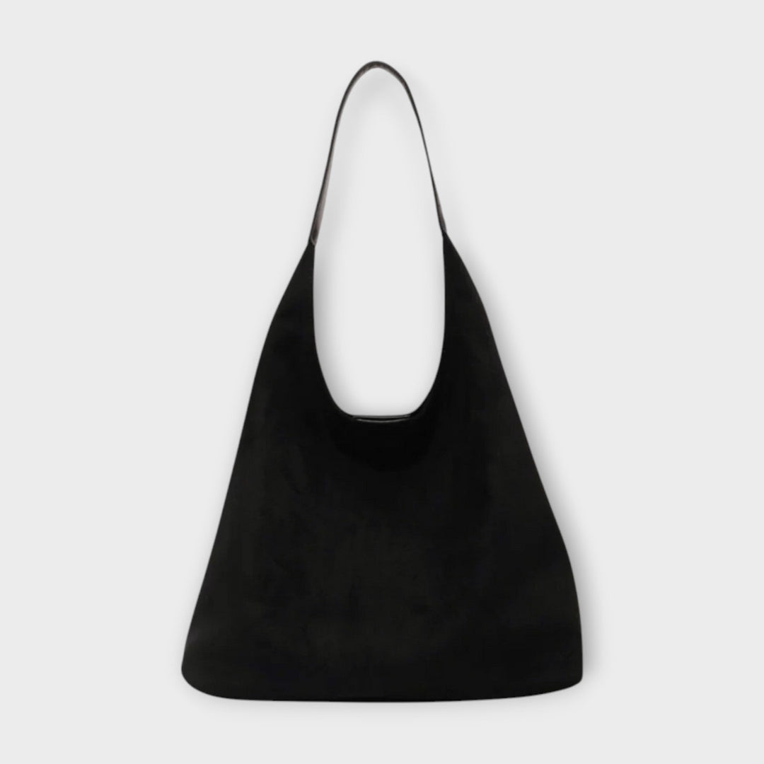 Borsa a mano Margherita di colore crema, indossata da una donna in un contesto urbano, evidenziando la sua versatilità.