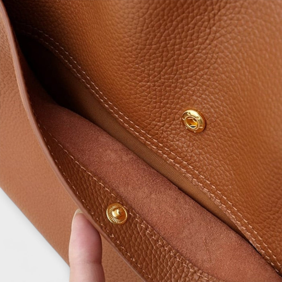 Primo piano dei manici robusti della borsa a tracolla color kaki, evidenziando il comfort e la presa ergonomica.