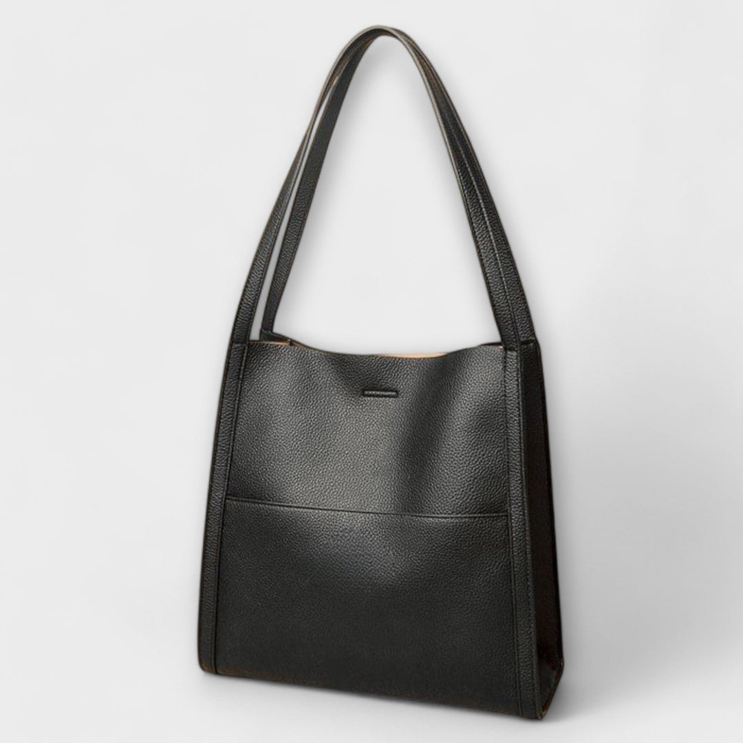Borsa a tracolla nera in movimento, catturata durante una passeggiata, sottolineando la sua praticità e leggerezza.