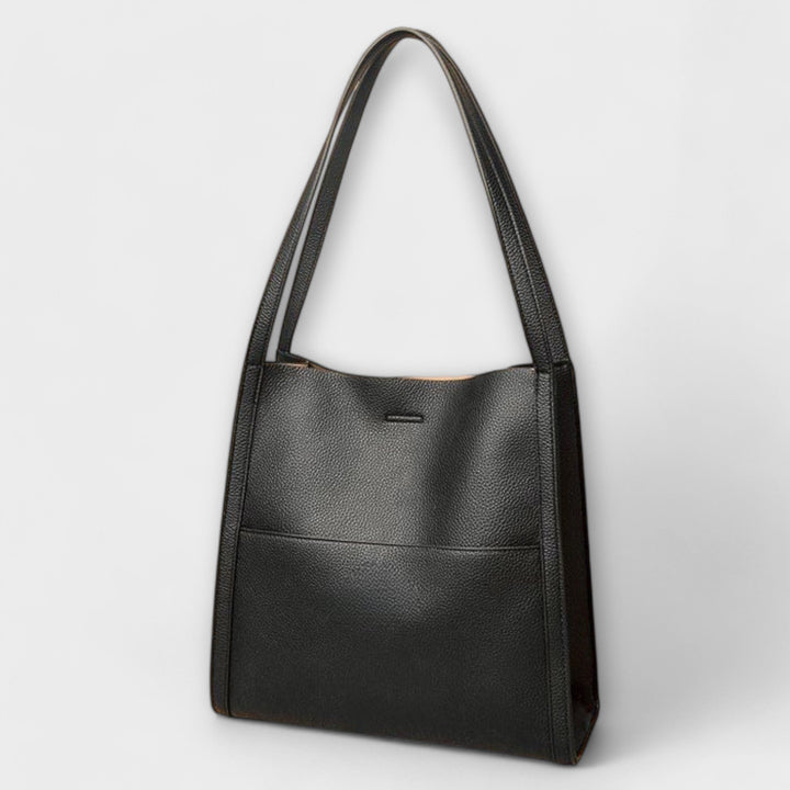 Borsa a tracolla nera in movimento, catturata durante una passeggiata, sottolineando la sua praticità e leggerezza.