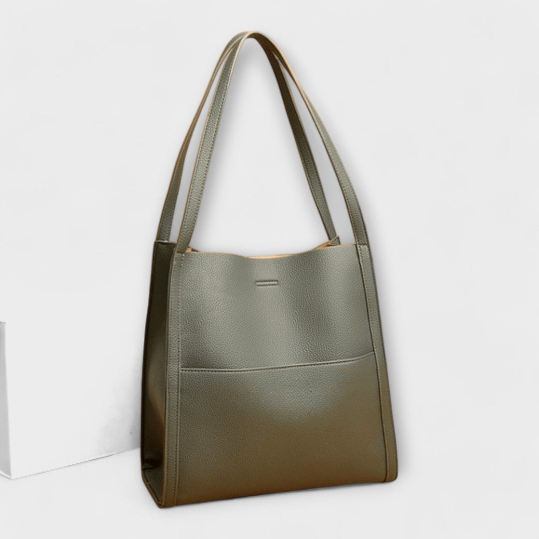 Borsa a tracolla grigia, vista laterale che evidenzia la profondità e la struttura del design elegante.