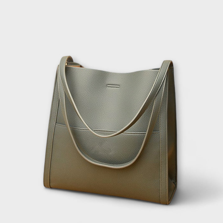 Borsa a tracolla color kaki, indossata a spalla da una donna in un contesto urbano, mostrando la versatilità.