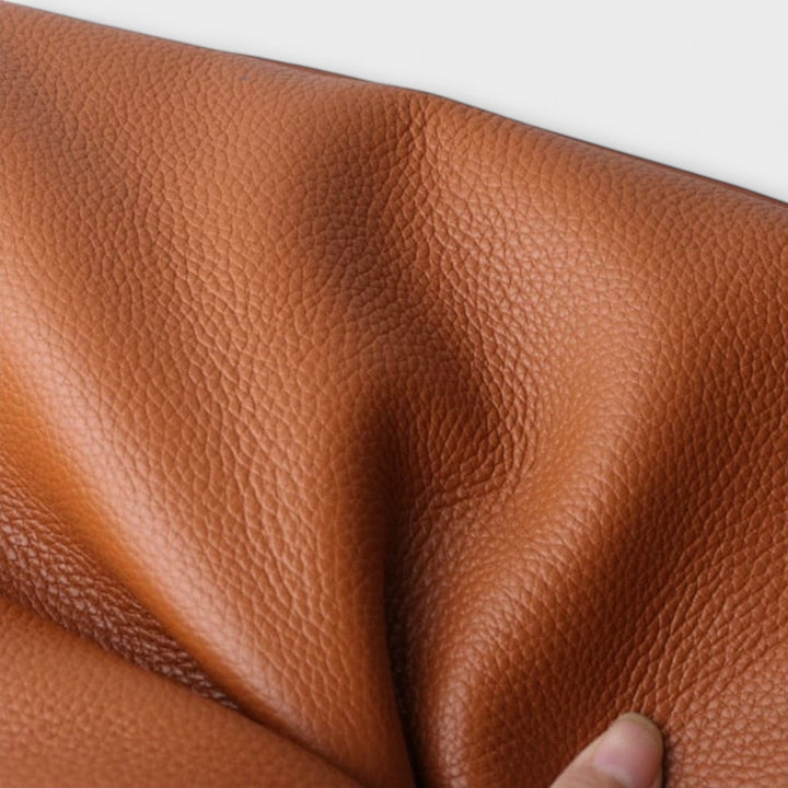 Borsa a tracolla grigia in un ambiente professionale, abbinata a un outfit da ufficio elegante e moderno.