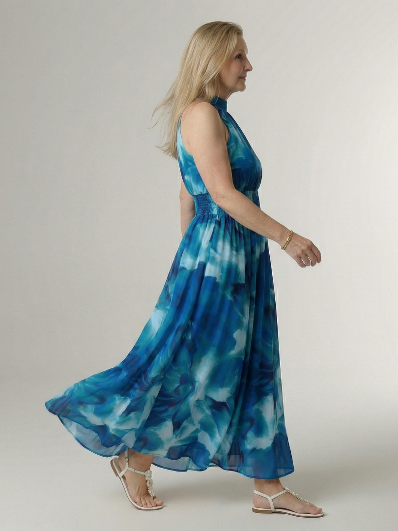 Modella cammina con l'abito midi Noemi blu, mostrando la vestibilità rilassata e fluida.