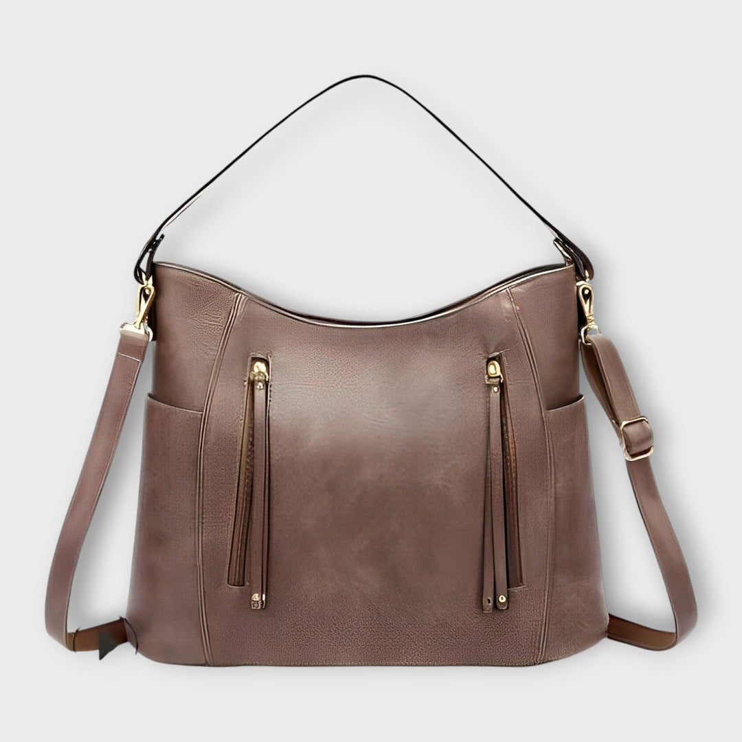 Donna che indossa la borsa a spalla Ophelia grigio chiaro, in un contesto urbano elegante.