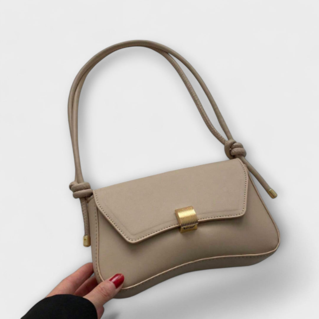 Borsa pieghevole Oriana color terracotta posata su una superficie chiara, vista frontale.