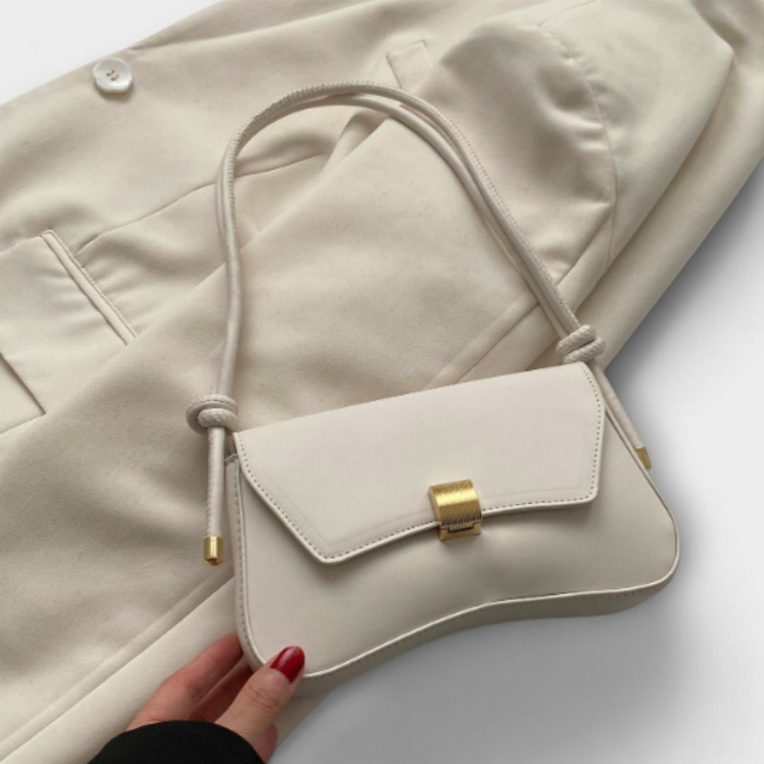 Dettaglio della texture e della chiusura della borsa pieghevole Oriana in tonalità beige.