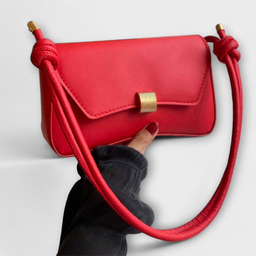 Donna che indossa la borsa pieghevole Oriana color verde a tracolla, in un contesto urbano.