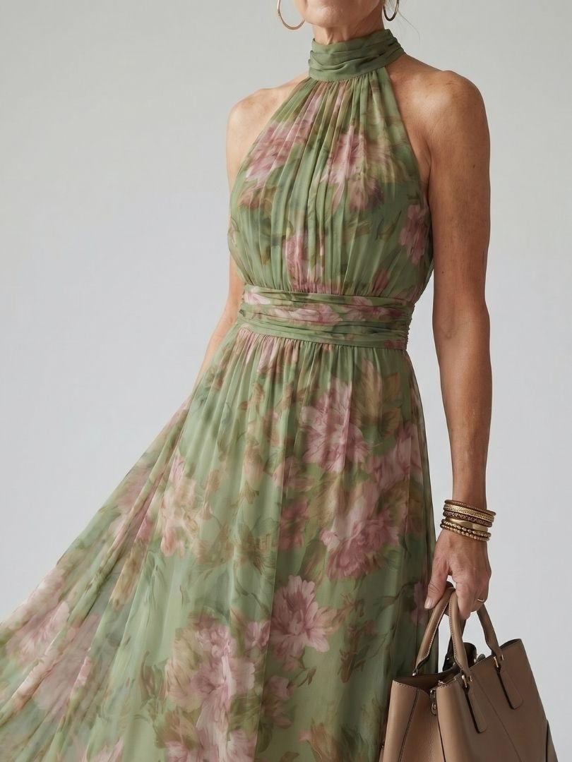 Modella che indossa l'abito midi halter verde salvia, mostrando la fluidità del tessuto e la lunghezza elegante.