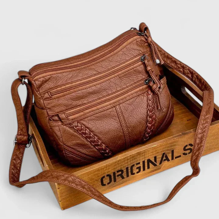 Borsa in pelle Sable color marrone, vista frontale con patta chiusa e tracolla.