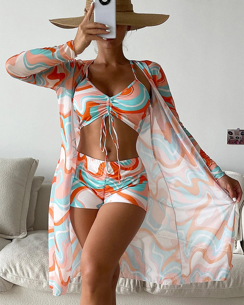 Modella in posa con il bikini a tre pezzi Solana arancione, mostrando il top e gli slip con stampa vivace.