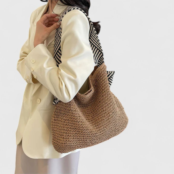 Modella che indossa la borsa Solara marrone a spalla, mostrando le cinghie distintive e la vestibilità.