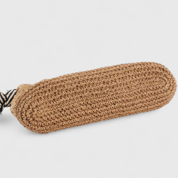 Borsa Solara marrone posata su una superficie, con le cinghie a spalla ben visibili e il design intrecciato.