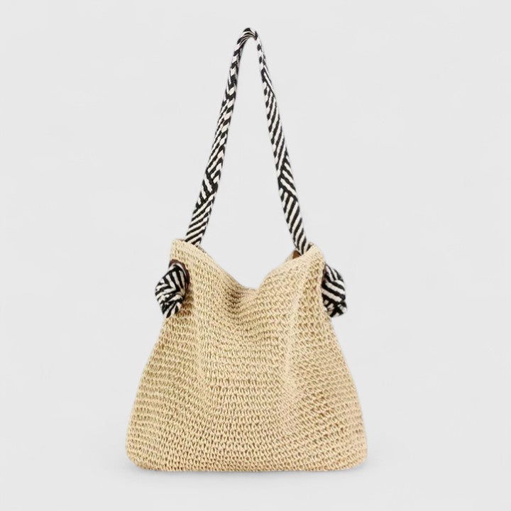 La borsa Solara beige appesa, catturando la texture del materiale e la forma complessiva di questo accessorio boho.