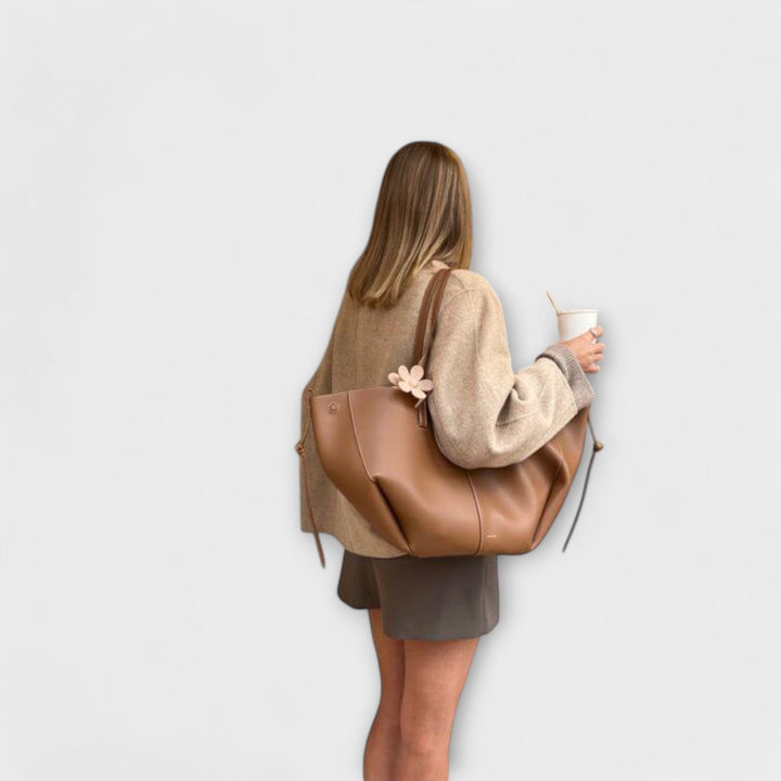 Interno aperto della borsa tote, rivelando lo spazio generoso e le tasche organizzative.