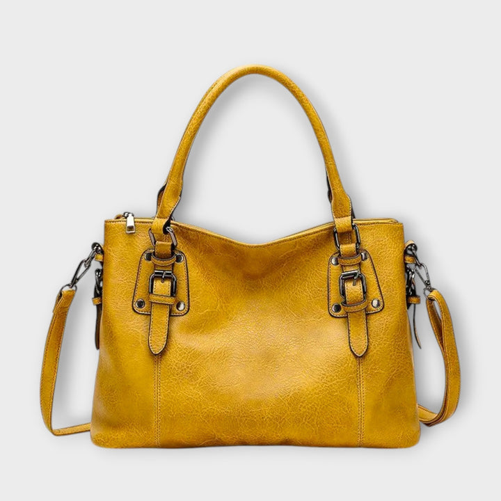 Borsa a spalla Stella di colore giallo su uno sfondo neutro, catturando la vivacità del colore e la forma della borsa.
