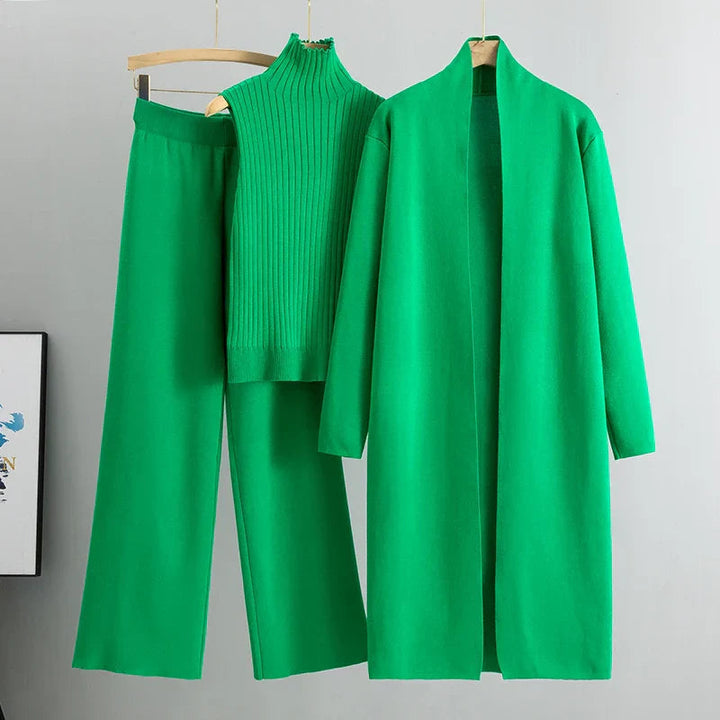 Set abiti donna a tre pezzi in verde, appoggiato su una superficie per mostrare tutti e tre i capi separati.