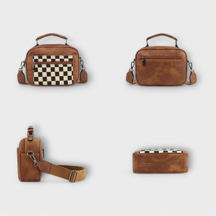 Borsa a spalla Talia appoggiata su una superficie neutra, mettendo in risalto la sua forma elegante e compatta.