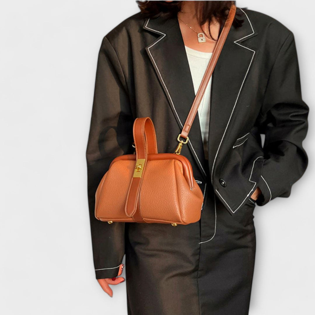 Borsa a spalla retrò color kaki, posizionata su una superficie neutra, evidenziando la texture del materiale.
